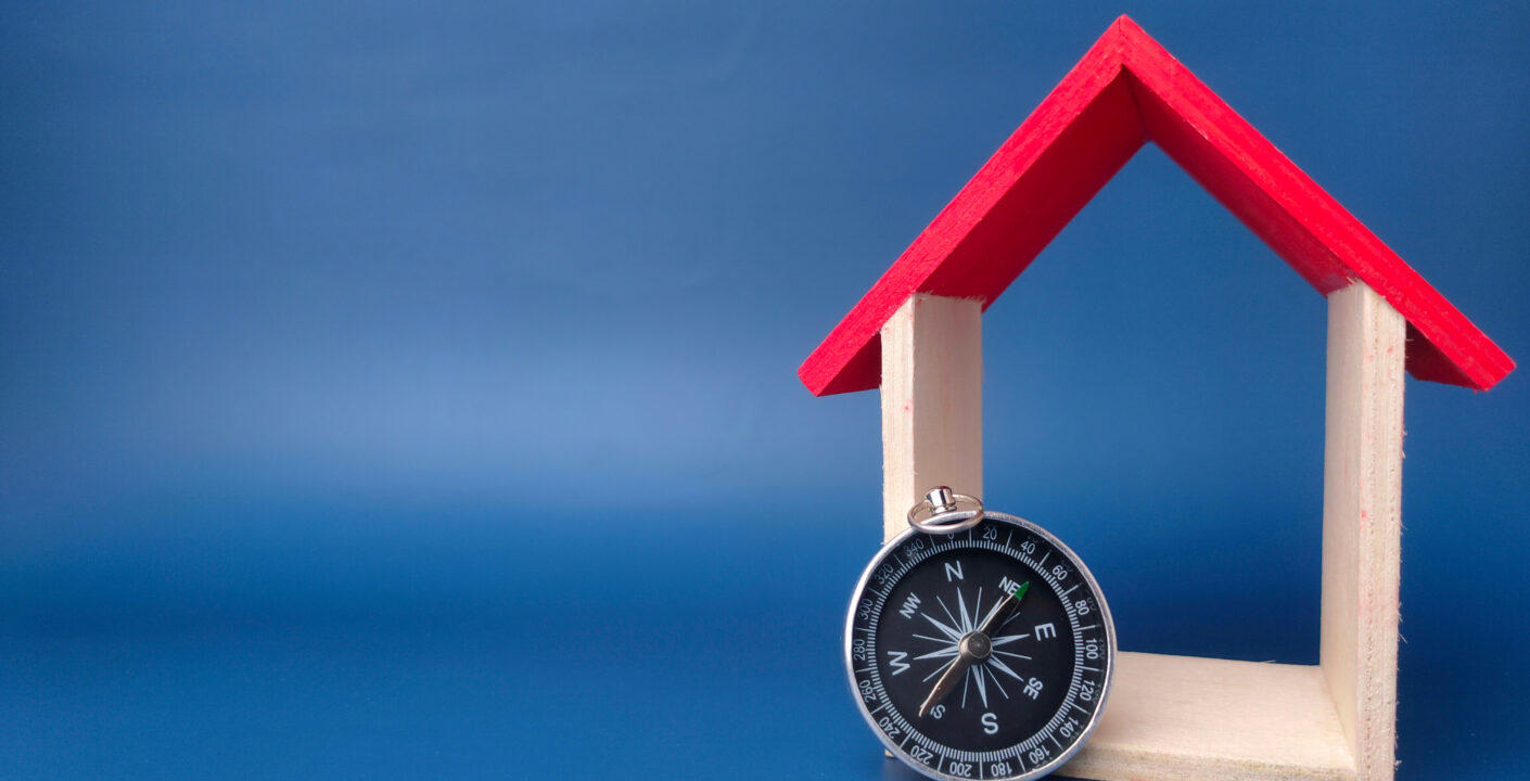 toy house compass blue background with copy space